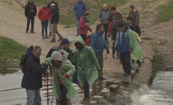 Grupo de personas de la parroquia cruzando un río